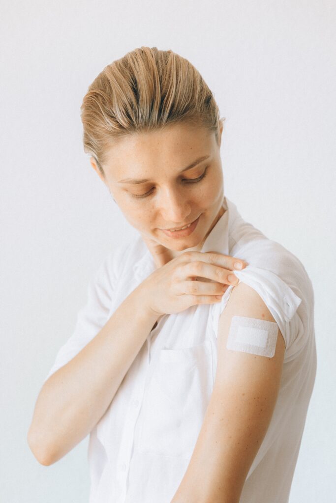 A woman shows her whooping cough vaccine bandage