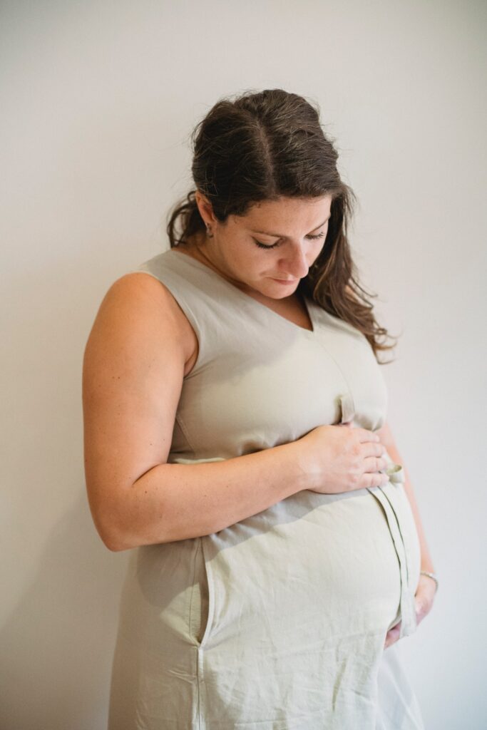 A surrogate mother holds her pregnant belly