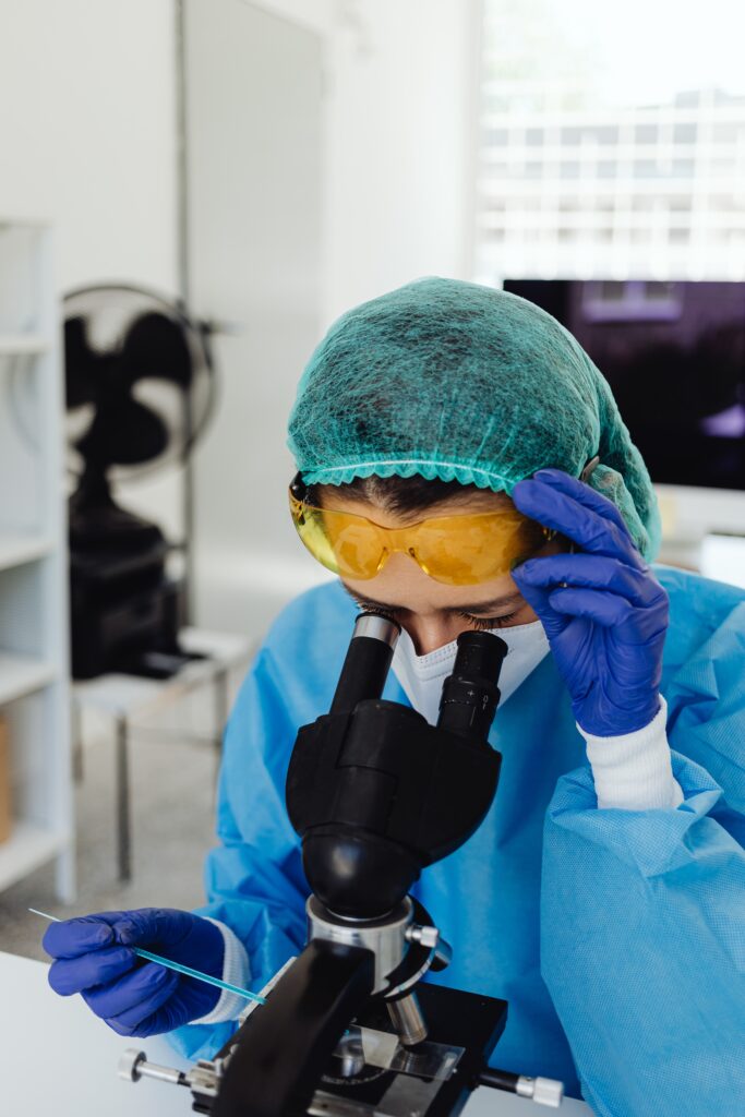 A fertility lab technician looks at an egg donation under a microscope