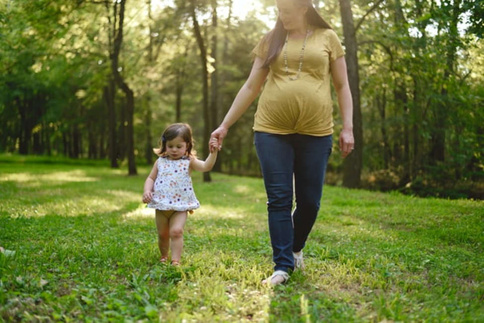 a pregnant surrogate walking with her young child