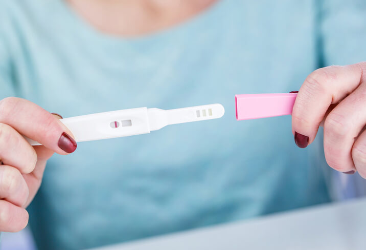 Woman looking at negative pregnancy test