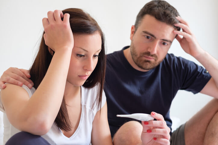 a worried couple holding a pregnancy test