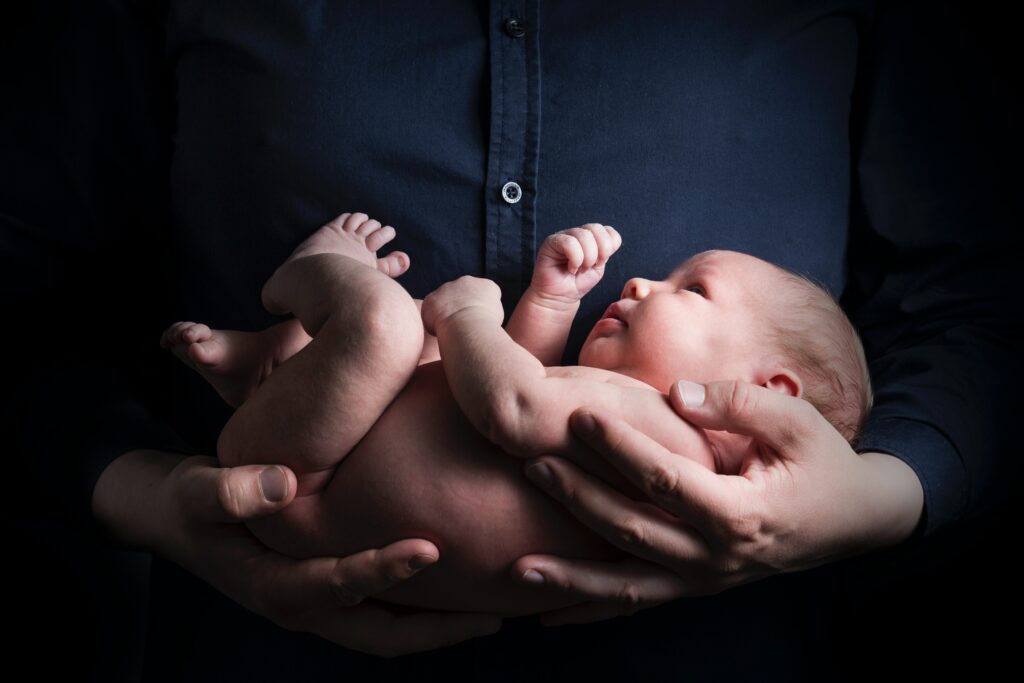 A man holding a newborn baby