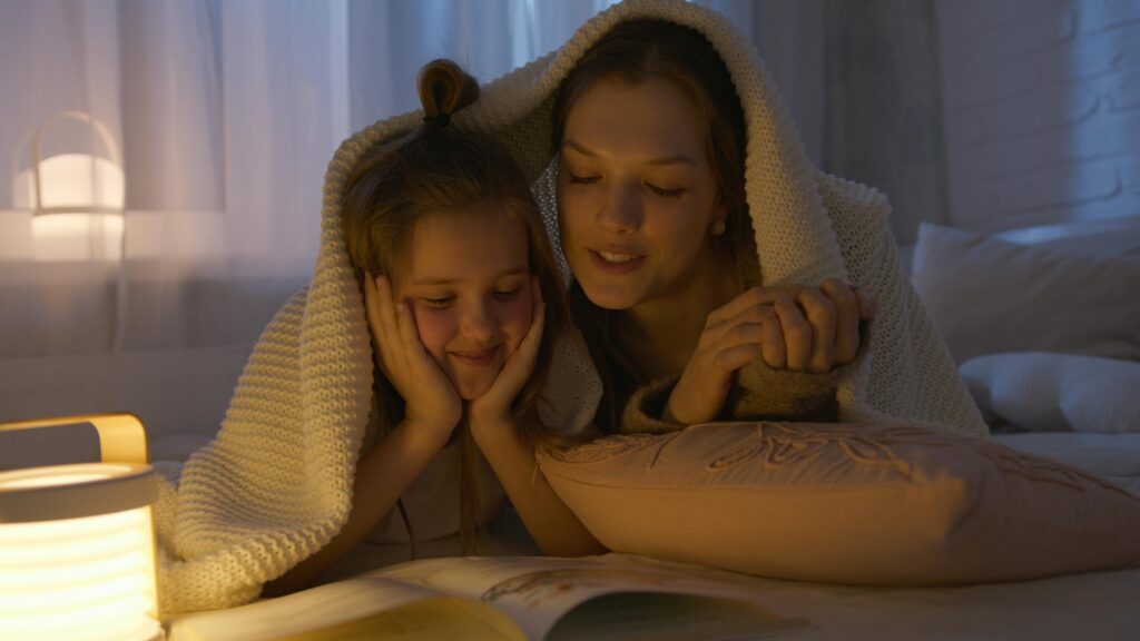 A mother and daughter reading a children’s book together.