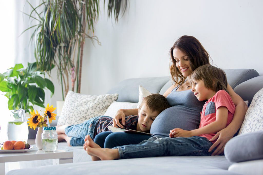 A surrogate mother reads a book to her two children.