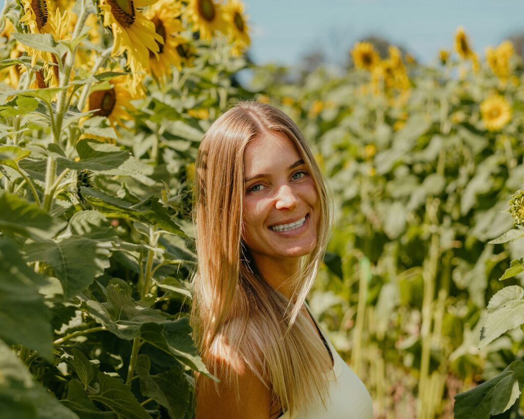 woman smiling among sunflowers